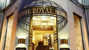 The entrance to Hotel Royal with a grand staircase, illuminated signs, and a classic architectural design. - Hotel Royal (Gothenburg)