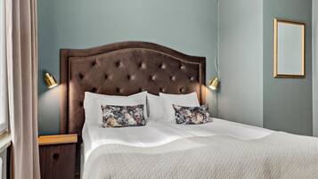 A neatly made bed with a tufted headboard, two bedside lamps, and floral-patterned pillows.