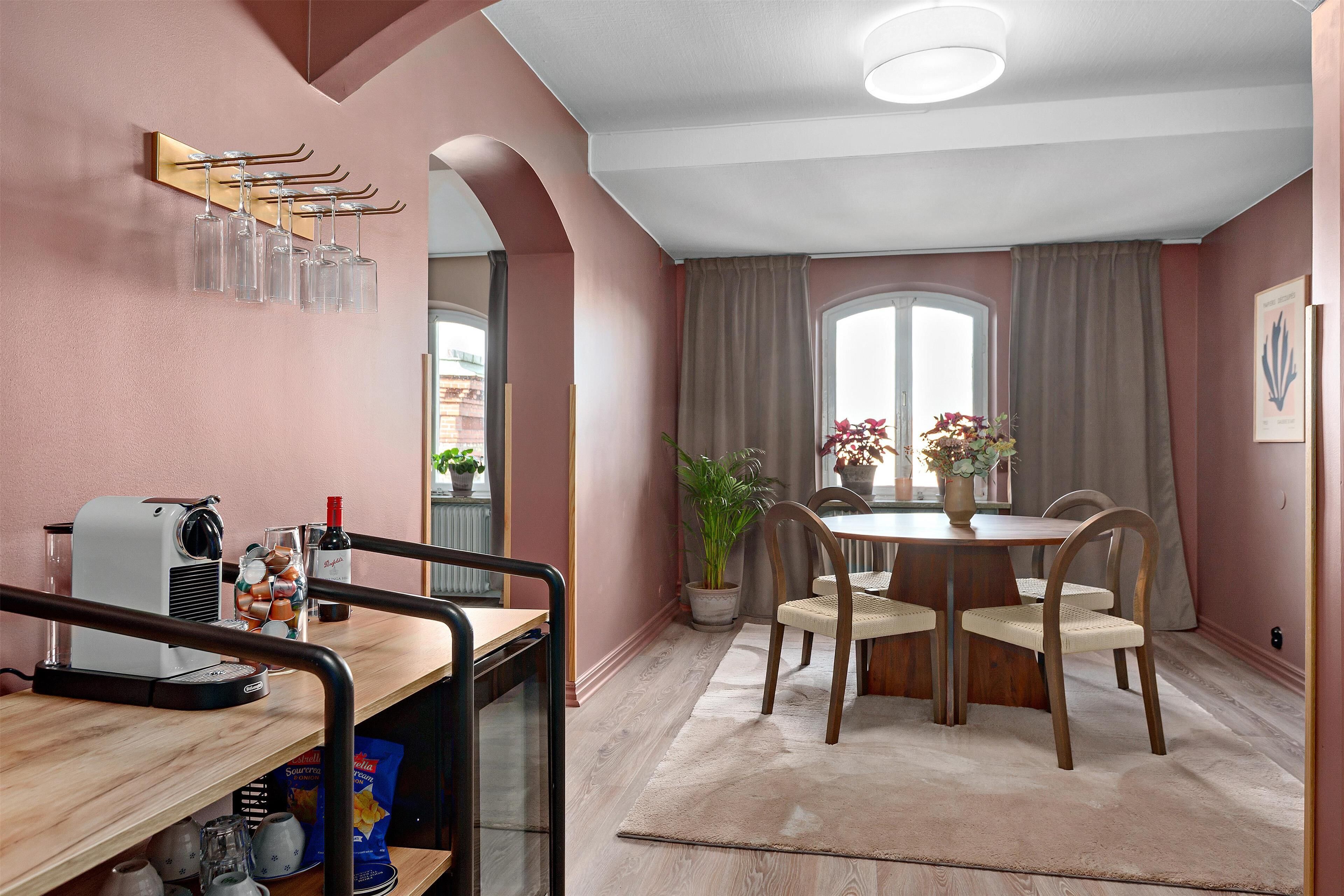 Ein gemütlicher Essbereich mit Holztisch, Stühlen und einem Blumentopf.