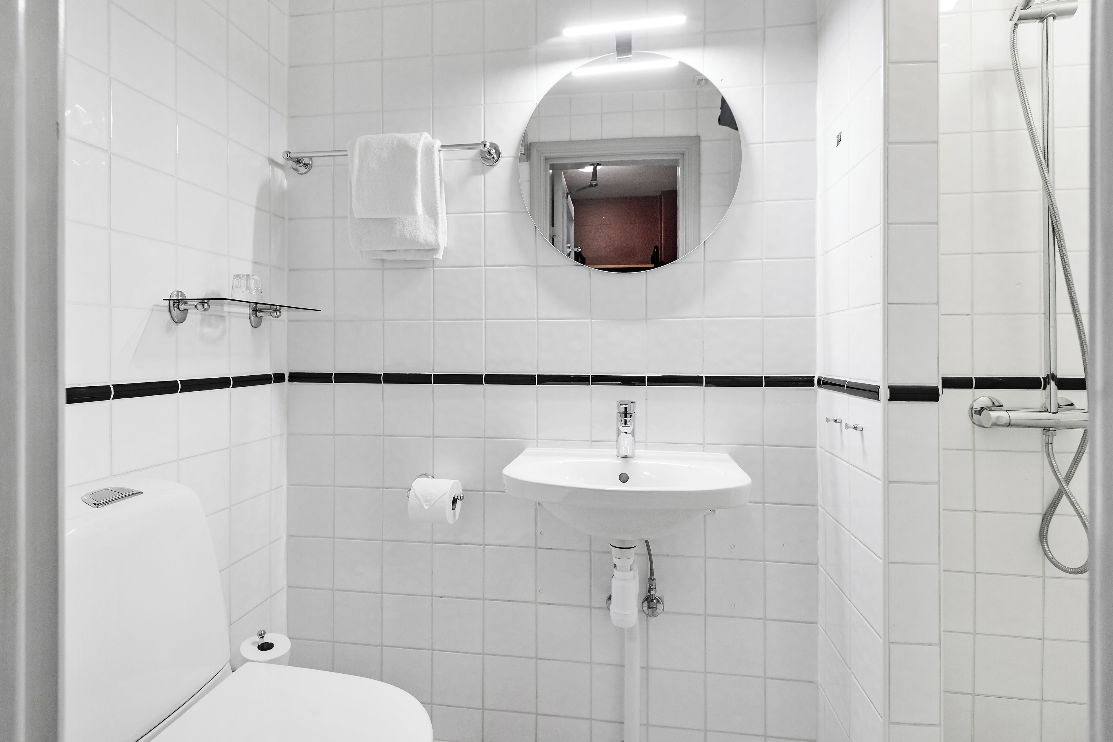 Ein Badezimmer mit Toilette, Waschbecken und Dusche.