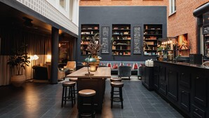 Un interior moderno con una zona de bar, asientos y un menú en pizarra.