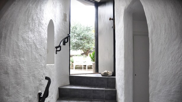 A staircase with a handrail leading to a door.