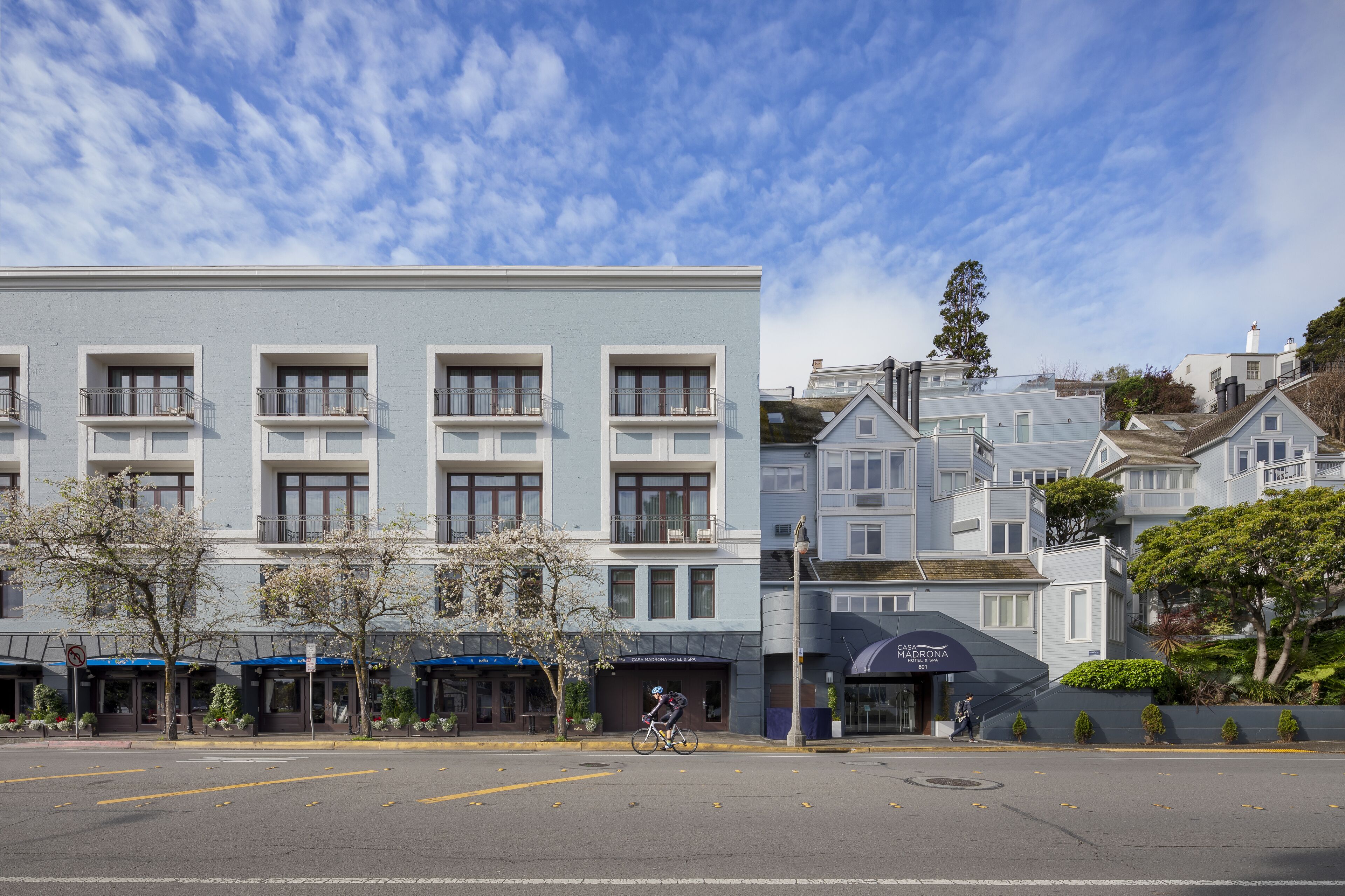 A multi-story hotel with a modern facade, balconies, and a clear sky.