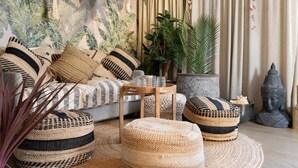A cozy living room with a sofa, ottomans, a coffee table, and decorative plants. - Radisson Blu Scandinavia Hotel (Gothenburg)