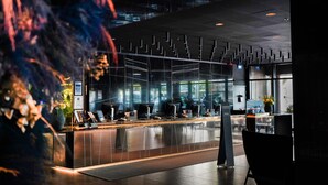 A modern reception area with a glass partition, reception desk, and seating area. - Radisson Blu Scandinavia Hotel (Gothenburg)