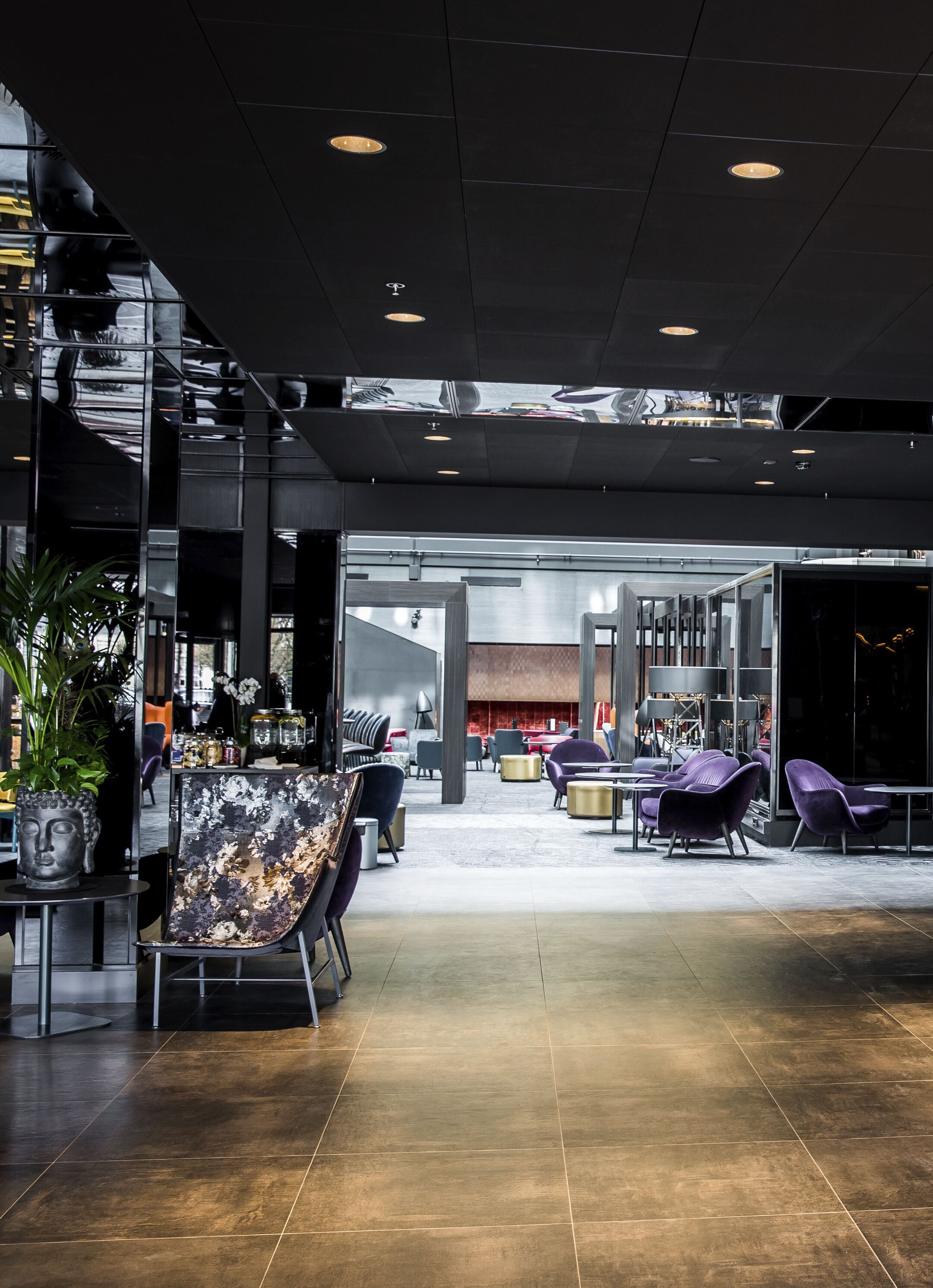 A modern interior with a central seating area, a staircase, and a view into another space.