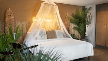 A bedroom with a canopy bed, a neon sign reading "Sweet Dreams," and various plants.