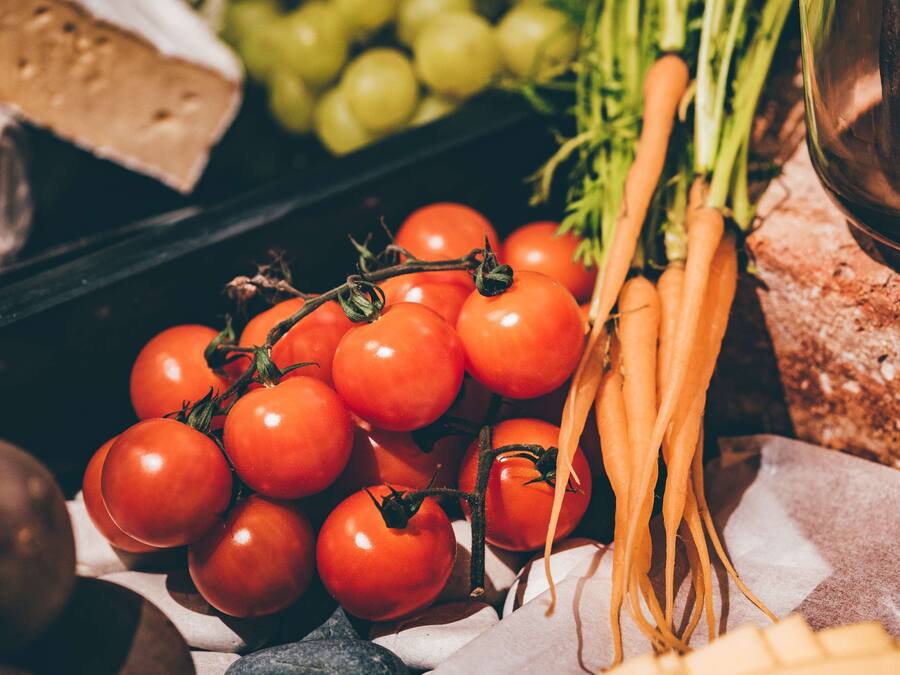 Eine Auswahl frischer Lebensmittel, darunter Tomaten, Karotten und Trauben.