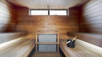 Un sauna avec des bancs en bois, une petite table et une fenêtre.