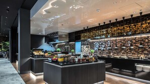 A modern kitchen with a marble floor, a central island with food items, and a patterned backsplash. - Radisson Collection Hotel, Tallinn (Tallinn)