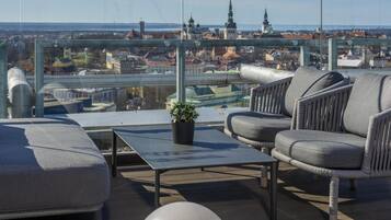 En takterrass med utsikt över stadsbilden, inklusive kyrktorn och en bro.