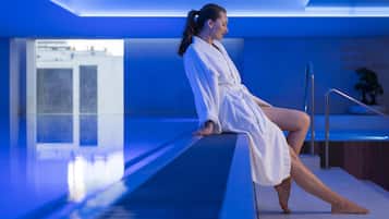Una piscina techada, sillones reclinables de piscina