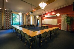 A conference room with a long table, chairs, a whiteboard, and a projector. - Q Hotel Växjö (Vaxjo)