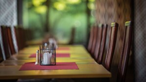 A long dining table with chairs, a salt and pepper shaker set, and a red placemat. - Q Hotel Växjö (Vaxjo)