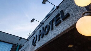 A hotel sign with the name "Q Hotel" on a stone facade. - Q Hotel Växjö (Vaxjo)