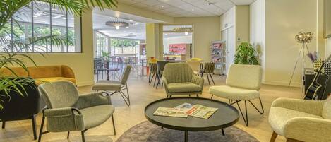 A modern lounge area with seating, a coffee table, and a piano.