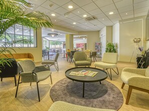 A modern lounge area with seating, a coffee table, and a piano. - ibis Cholet (Cholet)