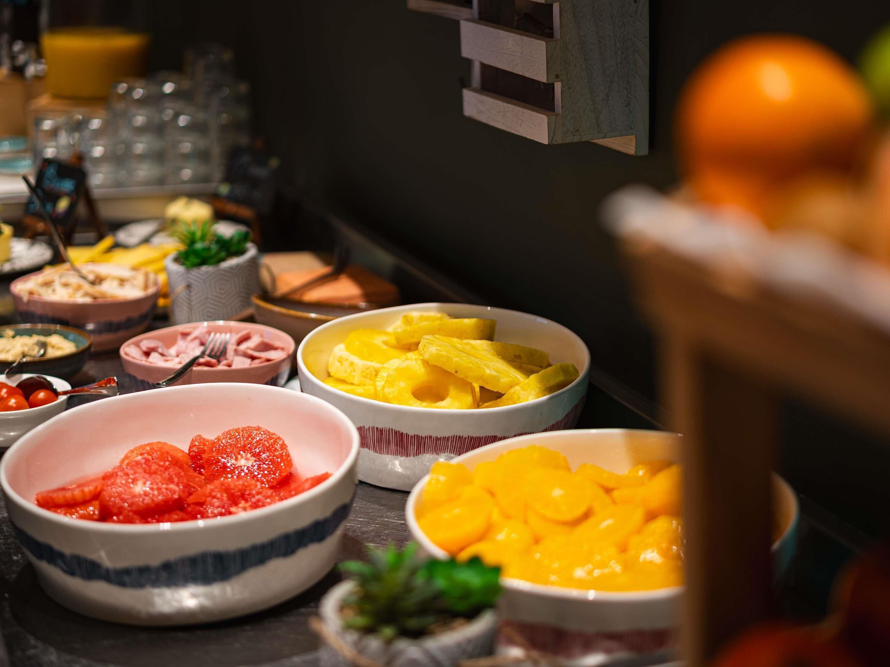 A buffet with various food items including fruits and dishes.