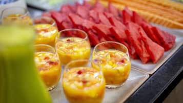 Una bandeja con vasitos de fruta y sandía en rodajas.