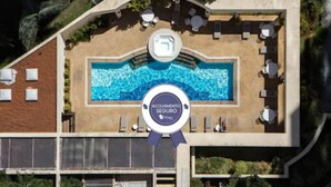 Vista aérea de un hotel con piscina, rodeado de zonas de estar al aire libre y un porche cubierto.