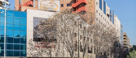 Un hotel con fachada moderna, varios pisos y un letrero llamativo.