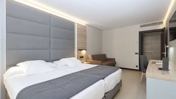 Quarto de hotel moderno com uma cama grande, uma escrivaninha e uma cadeira.