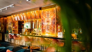 Eine Bar mit Marmorwänden, einer Theke und mehreren Stühlen.