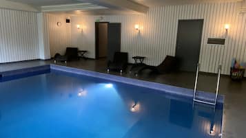 Una piscina techada, sillones reclinables de piscina
