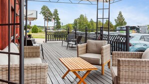 Un espace extérieur abrité, aménagé avec des meubles en osier et une table en bois.