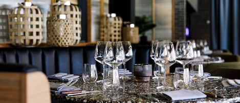 A restaurant table set with multiple wine glasses, a small decorative bowl, and neatly arranged cutlery.