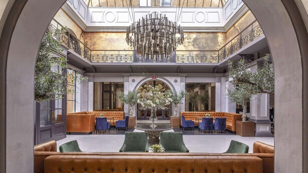 A spacious lobby with a central fountain, seating areas, and a chandelier. - Oatlands Park Hotel (Weybridge)