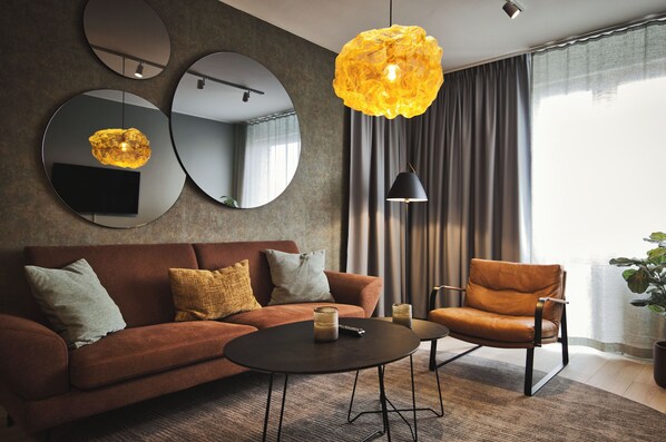 Relax in this stylish living room with a brown leather sofa, round coffee table, and armchair.