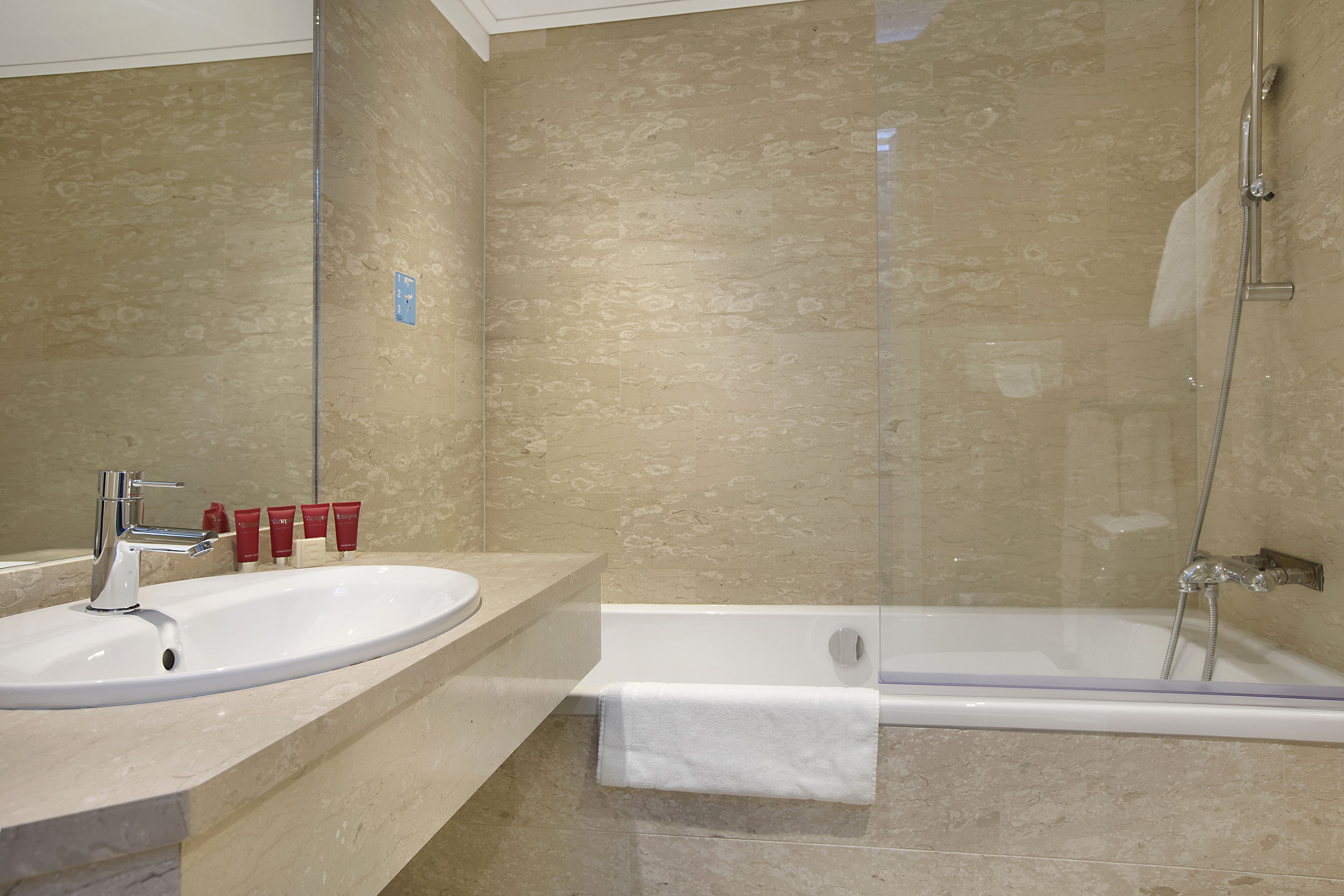 A bathroom with a sink, mirror, and shower.