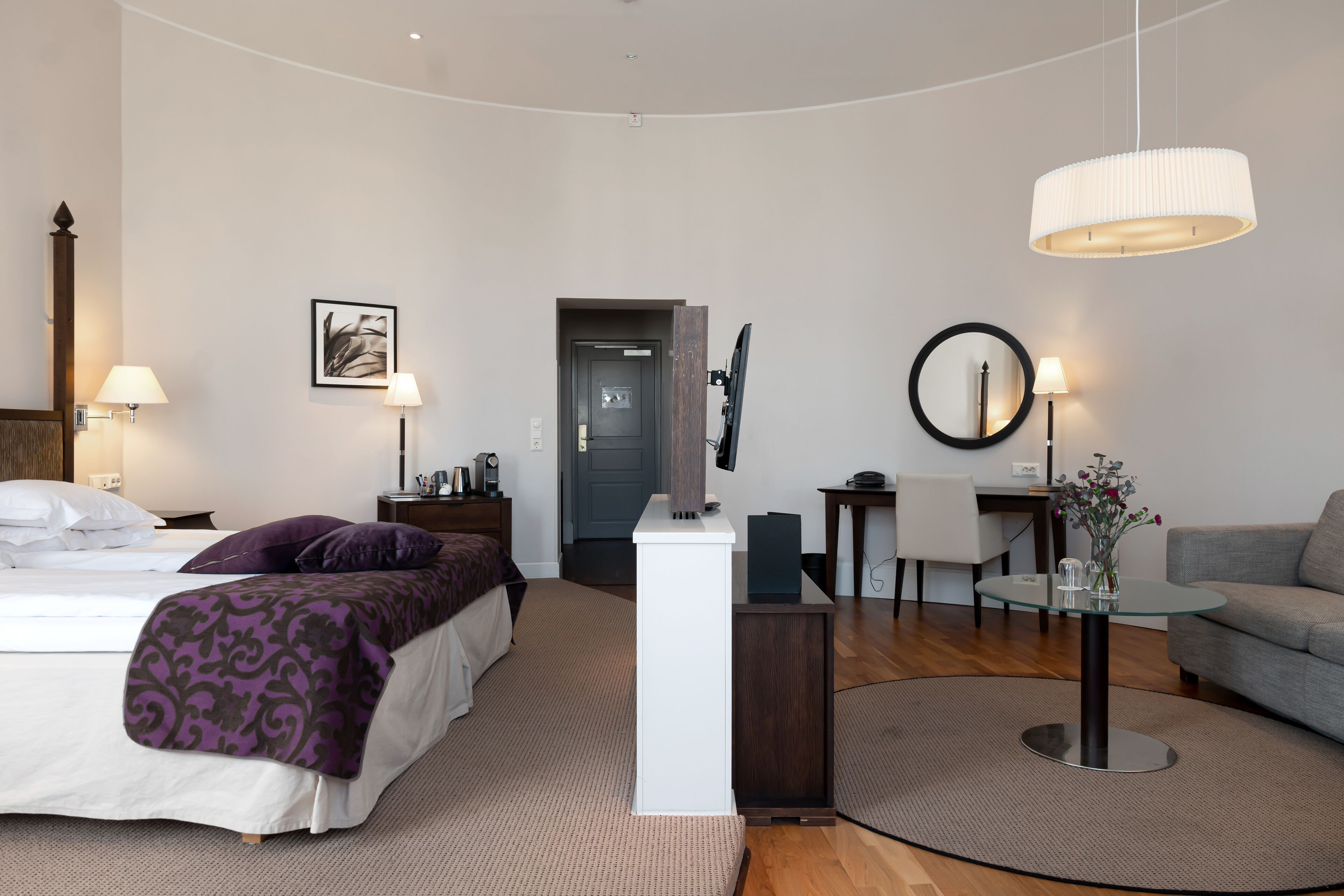 Une chambre d’hôtel moderne équipée d’un lit, d’un bureau, d’un canapé et d’une table à manger.