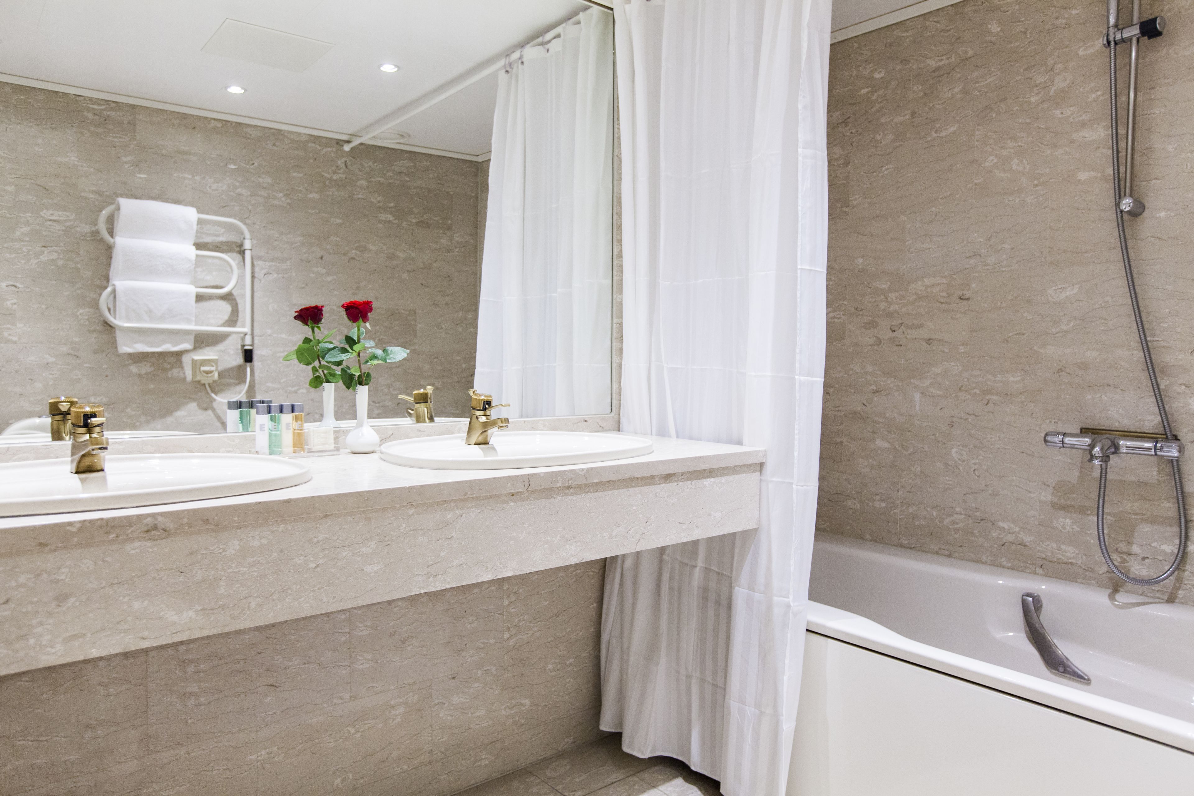Une salle de bain avec deux lavabos, une baignoire et une douche.