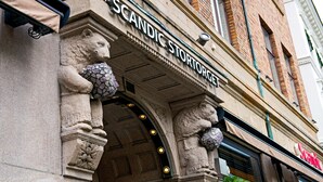 A building facade with the name "SCANDIC STORTORGE" and stone lion statues. - Scandic Stortorget (Malmö)
