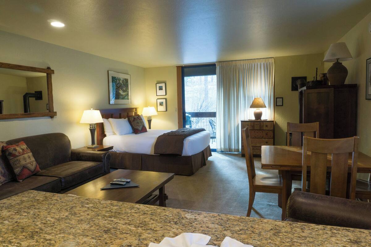 Una habitación de hotel con cama, sofá, escritorio y silla.