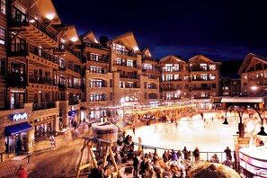 A hotel with multiple floors, balconies, and a central courtyard with an ice rink.