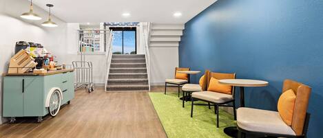 A modern interior with a teal cabinet, wooden flooring, and a green carpet leading to a staircase.