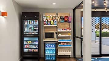 Zona de venta con diversas opciones de bocadillos y bebidas, incluyendo microondas y refrigeradores.