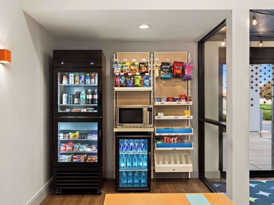 Zona de venta con diversas opciones de bocadillos y bebidas, incluyendo microondas y refrigeradores.
