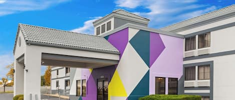 A modern building with a geometric facade and a covered entrance.