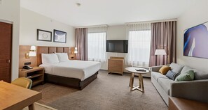 A hotel room with a bed, a desk, a sofa, a TV, and a window with curtains. - Best Western Plus Hannaford Inn & Suites (Cincinnati)