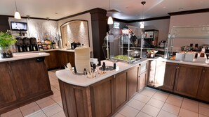 A modern kitchen with a central island, built-in appliances, and a variety of food and drink dispensers.