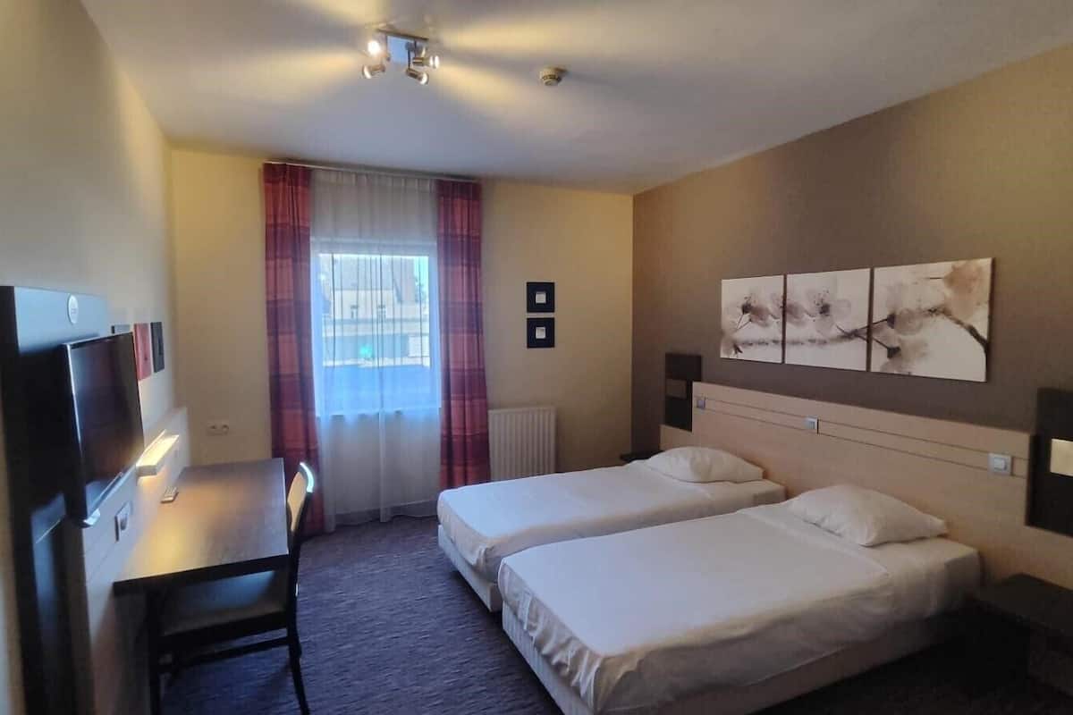 Chambre avec lits jumeaux | Minibar, coffre-fort, bureau, rideaux d’obscurcissement