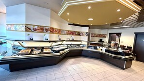 A buffet area with various food displays and a modern ceiling design.