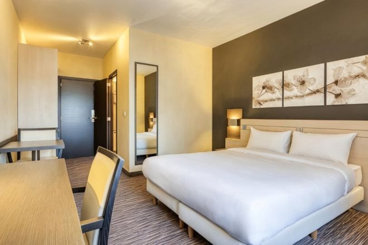 Een hotelkamer met een bed, een bureau en een stoel.