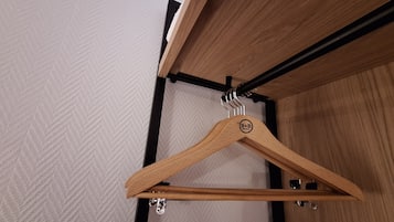 A wooden hanger with a logo on a metal rod.