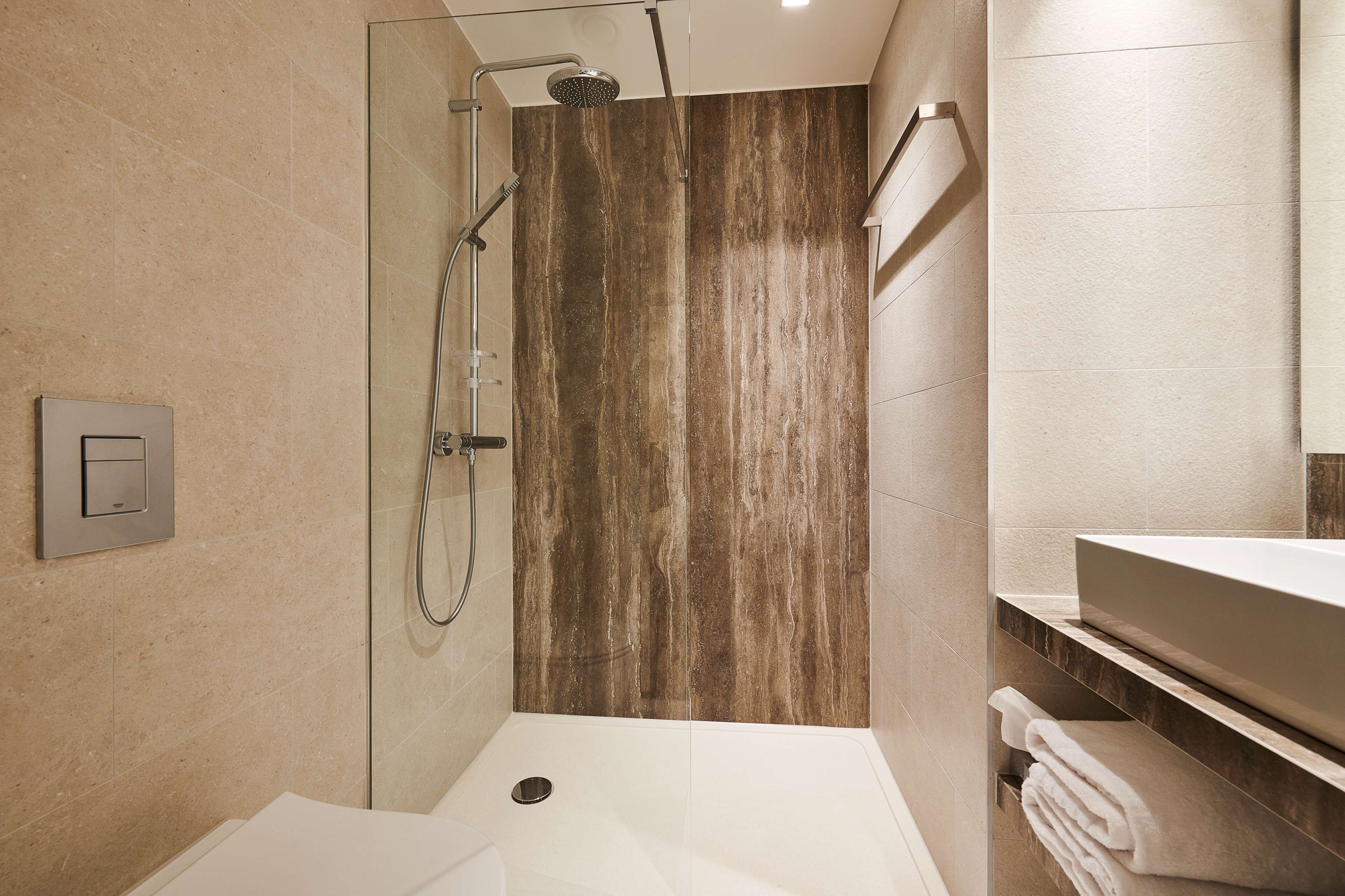 A modern bathroom with a shower, a sink, and a vanity.