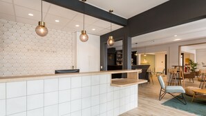 Een moderne keuken met een witte betegelde spatwand, een houten aanrechtblad en hanglampen.